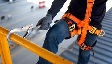 Trabajador usando arnés de seguridad para descender en construcción