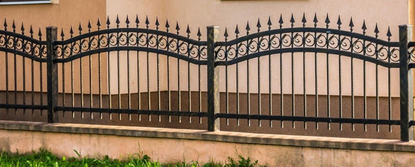 Reja de herrería elaborada con pefiles juntos sobre la barda de una casa