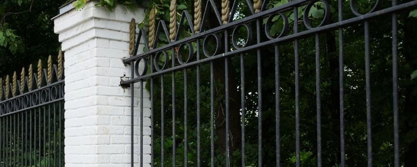 Reja de herrería fija sobre una barda de piedra en una casa
