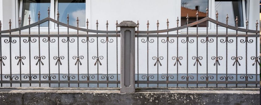 Reja de herrería elaborada con perfiles instalada sobre la barda de un hogar