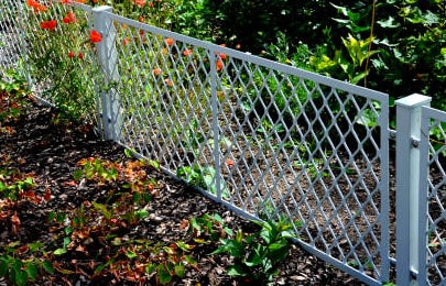 Acercamiento a una rejilla diseño diamante en el jardín de una casa 