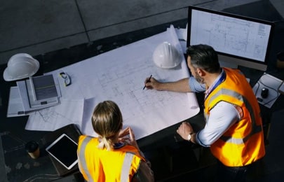 Arquitectos leyendo planos arquitectónicos de una casa