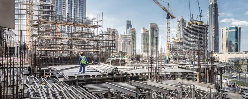 Enormes edificaciones de acero en construcción en medio de una ciudad