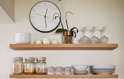 Repisas flotantes modernas de madera con vasos, platos, copas y frascos de especias para cocina