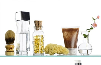 Dos repisas flotantes modernas hechas de cristal con diferentes productos para baño