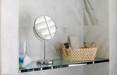 Dos repisas flotantes modernas de vidrio para baño con distintas decoraciones y elementos