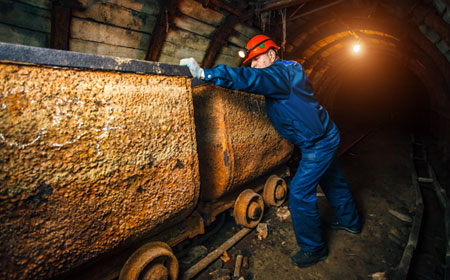 Trabajador de la industria metalúrgica especializado en minería guiando un carro de extracción