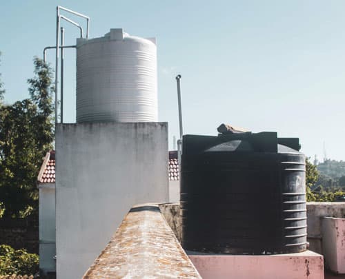 Tinacos en la azotea de una casa con bases hechas de concreto